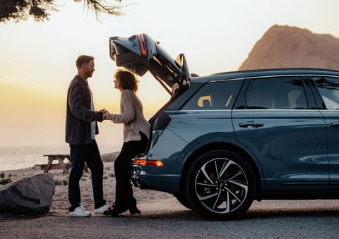 A couple share a moment together outside a 2025 Lincoln Corsair® SUV near the open liftgate. | Parks Lincoln of Wesley Chapel in Wesley Chapel FL