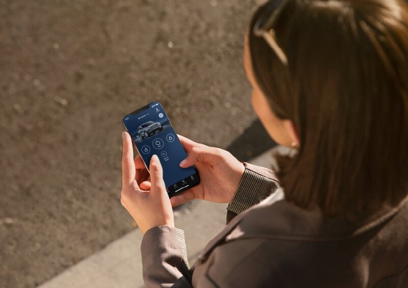 A person is shown interacting with a smartphone to connect to a Lincoln vehicle via the Lincoln Way® App. | Parks Lincoln of Wesley Chapel in Wesley Chapel FL