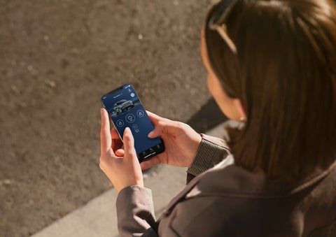A person is shown interacting with a smartphone to connect to a Lincoln vehicle via the Lincoln Way® App. | Parks Lincoln of Wesley Chapel in Wesley Chapel FL