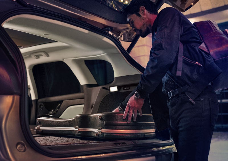 A man is shown loading cargo into the rear of a 2024 Lincoln Corsair® SUV with the second-row seats folded flat. | Parks Lincoln of Wesley Chapel in Wesley Chapel FL