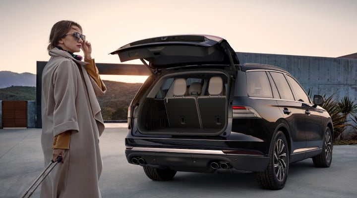 A woman approaches a 2026 Lincoln Aviator® SUV with its rear liftgate open. | Parks Lincoln of Wesley Chapel in Wesley Chapel FL
