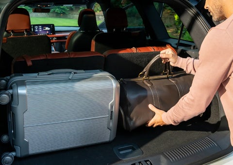 A man loads luggage into the rear of a 2026 Lincoln Aviator® SUV through the opened rear liftgate. | Parks Lincoln of Wesley Chapel in Wesley Chapel FL