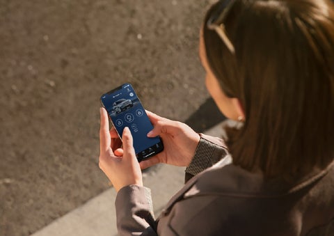 A person is shown interacting with a smartphone to connect to a Lincoln vehicle via the Lincoln Way® app. | Parks Lincoln of Wesley Chapel in Wesley Chapel FL