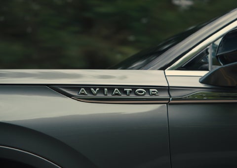 The driver’s side door and fender badging of a gray 2027 Lincoln Aviator® SUV are showcased. | Parks Lincoln of Wesley Chapel in Wesley Chapel FL